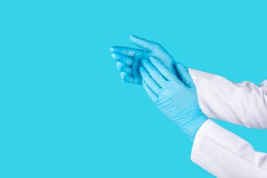 Tıbbi nitril eldivenler, mavi başlık, desenli arka planda tek kullanımlık tıbbi maske. Tıbbi koruyucu giysi. Cerrahi lateks eldivenler. Lastik eldiven üretimi. Tıp konsepti. Üst Manzara. Metni kopyala