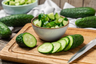 Ahşap arka planda salatalık. Arka planda bir parça salatalık. Taze organik yeşil salatalık turşusu. Vejetaryen. Salata malzemesi. Çiftlik sebzeleri. Sebzeleri bıçakla kes. Mesaj için yer var. Boşluğu kopyala