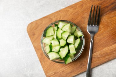 Ahşap arka planda salatalık. Arka planda bir parça salatalık. Taze organik yeşil salatalık turşusu. Vejetaryen. Salata malzemesi. Çiftlik sebzeleri. Sebzeleri bıçakla kes. Mesaj için yer var. Boşluğu kopyala