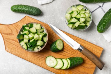 Ahşap arka planda salatalık. Arka planda bir parça salatalık. Taze organik yeşil salatalık turşusu. Vejetaryen. Salata malzemesi. Çiftlik sebzeleri. Sebzeleri bıçakla kes. Mesaj için yer var. Boşluğu kopyala