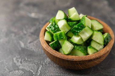 Ahşap arka planda salatalık. Arka planda bir parça salatalık. Taze organik yeşil salatalık turşusu. Vejetaryen. Salata malzemesi. Çiftlik sebzeleri. Sebzeleri bıçakla kes. Mesaj için yer var. Boşluğu kopyala