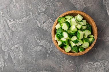 Ahşap arka planda salatalık. Arka planda bir parça salatalık. Taze organik yeşil salatalık turşusu. Vejetaryen. Salata malzemesi. Çiftlik sebzeleri. Sebzeleri bıçakla kes. Mesaj için yer var. Boşluğu kopyala