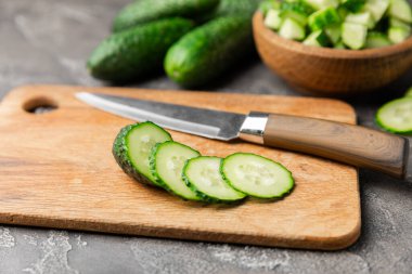 Ahşap arka planda salatalık. Arka planda bir parça salatalık. Taze organik yeşil salatalık turşusu. Vejetaryen. Salata malzemesi. Çiftlik sebzeleri. Sebzeleri bıçakla kes. Mesaj için yer var. Boşluğu kopyala