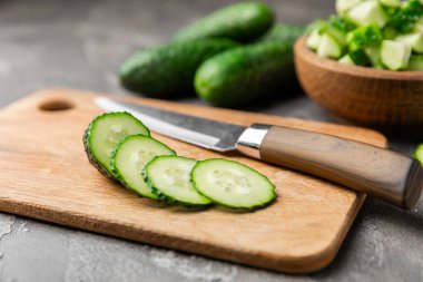 Ahşap arka planda salatalık. Arka planda bir parça salatalık. Taze organik yeşil salatalık turşusu. Vejetaryen. Salata malzemesi. Çiftlik sebzeleri. Sebzeleri bıçakla kes. Mesaj için yer var. Boşluğu kopyala