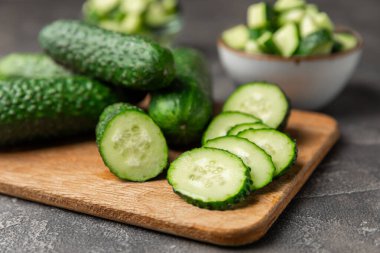 Ahşap arka planda salatalık. Arka planda bir parça salatalık. Taze organik yeşil salatalık turşusu. Vejetaryen. Salata malzemesi. Çiftlik sebzeleri. Sebzeleri bıçakla kes. Mesaj için yer var. Boşluğu kopyala