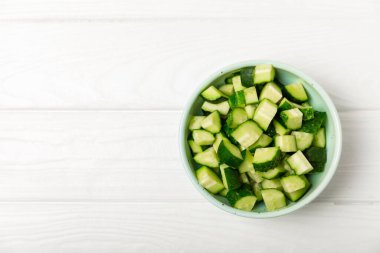 Ahşap arka planda salatalık. Arka planda bir parça salatalık. Taze organik yeşil salatalık turşusu. Vejetaryen. Salata malzemesi. Çiftlik sebzeleri. Sebzeleri bıçakla kes. Mesaj için yer var. Boşluğu kopyala