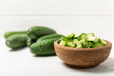 Ahşap arka planda salatalık. Arka planda bir parça salatalık. Taze organik yeşil salatalık turşusu. Vejetaryen. Salata malzemesi. Çiftlik sebzeleri. Sebzeleri bıçakla kes. Mesaj için yer var. Boşluğu kopyala