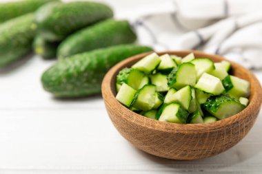 Ahşap arka planda salatalık. Arka planda bir parça salatalık. Taze organik yeşil salatalık turşusu. Vejetaryen. Salata malzemesi. Çiftlik sebzeleri. Sebzeleri bıçakla kes. Mesaj için yer var. Boşluğu kopyala