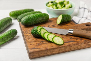 Ahşap arka planda salatalık. Arka planda bir parça salatalık. Taze organik yeşil salatalık turşusu. Vejetaryen. Salata malzemesi. Çiftlik sebzeleri. Sebzeleri bıçakla kes. Mesaj için yer var. Boşluğu kopyala