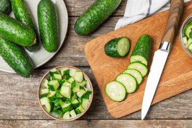 Ahşap arka planda salatalık. Arka planda bir parça salatalık. Taze organik yeşil salatalık turşusu. Vejetaryen. Salata malzemesi. Çiftlik sebzeleri. Sebzeleri bıçakla kes. Mesaj için yer var. Boşluğu kopyala