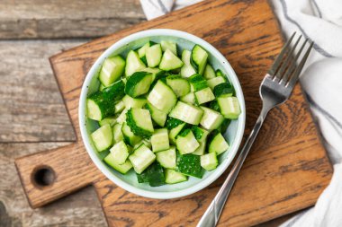 Ahşap arka planda salatalık. Arka planda bir parça salatalık. Taze organik yeşil salatalık turşusu. Vejetaryen. Salata malzemesi. Çiftlik sebzeleri. Sebzeleri bıçakla kes. Mesaj için yer var. Boşluğu kopyala
