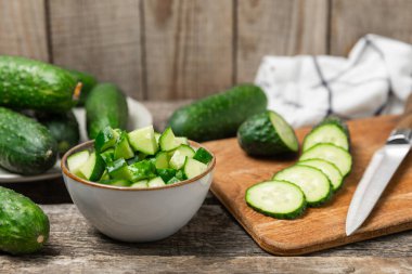 Ahşap arka planda salatalık. Arka planda bir parça salatalık. Taze organik yeşil salatalık turşusu. Vejetaryen. Salata malzemesi. Çiftlik sebzeleri. Sebzeleri bıçakla kes. Mesaj için yer var. Boşluğu kopyala