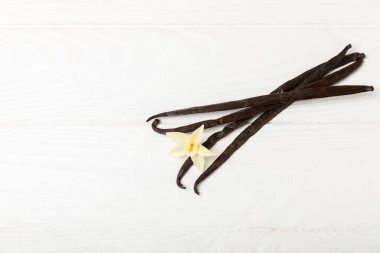 Dokulu bir arka planda vanilya kabukları. Vanilya çiçekleri ve tohumlar. Vanilyalı fasulye. Hamur işleri ve tatlılar için baharatlı baharat. Baharat. Mesaj için yer var. Boşluğu Kopyala