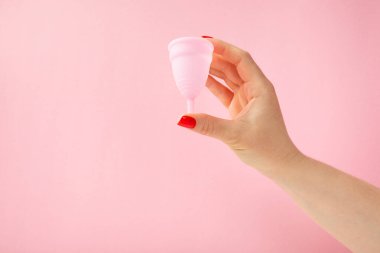 Aybaşı bardağı parlak bir arka planda. Hijyenik peçeteler, tamponlar ve regl kupası. Kritik günler, regl dönemi kavramı. Kadın hijyen ürünü. Kadın sağlığı kavramı. Adet öncesi sendromu. Boşluğu kopyala