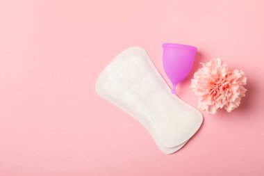 Aybaşı bardağı parlak bir arka planda. Hijyenik peçeteler, tamponlar ve regl kupası. Kritik günler, regl dönemi kavramı. Kadın hijyen ürünü. Kadın sağlığı kavramı. Adet öncesi sendromu. Boşluğu kopyala