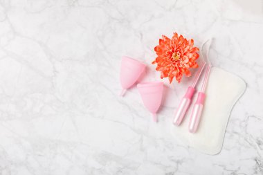 Aybaşı bardağı parlak bir arka planda. Hijyenik peçeteler, tamponlar ve regl kupası. Kritik günler, regl dönemi kavramı. Kadın hijyen ürünü. Kadın sağlığı kavramı. Adet öncesi sendromu. Boşluğu kopyala