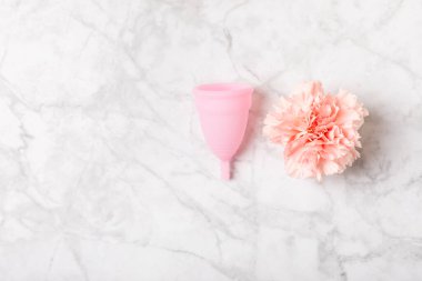 Aybaşı bardağı parlak bir arka planda. Hijyenik peçeteler, tamponlar ve regl kupası. Kritik günler, regl dönemi kavramı. Kadın hijyen ürünü. Kadın sağlığı kavramı. Adet öncesi sendromu. Boşluğu kopyala