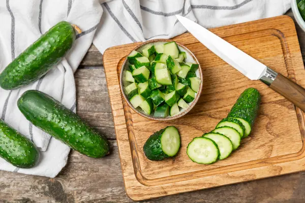 Ahşap arka planda salatalık. Arka planda bir parça salatalık. Taze organik yeşil salatalık turşusu. Vejetaryen. Salata malzemesi. Çiftlik sebzeleri. Sebzeleri bıçakla kes. Mesaj için yer var. Boşluğu kopyala