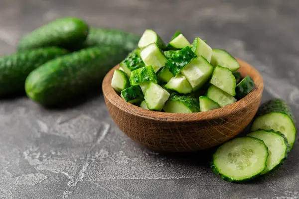 Ahşap arka planda salatalık. Arka planda bir parça salatalık. Taze organik yeşil salatalık turşusu. Vejetaryen. Salata malzemesi. Çiftlik sebzeleri. Sebzeleri bıçakla kes. Mesaj için yer var. Boşluğu kopyala