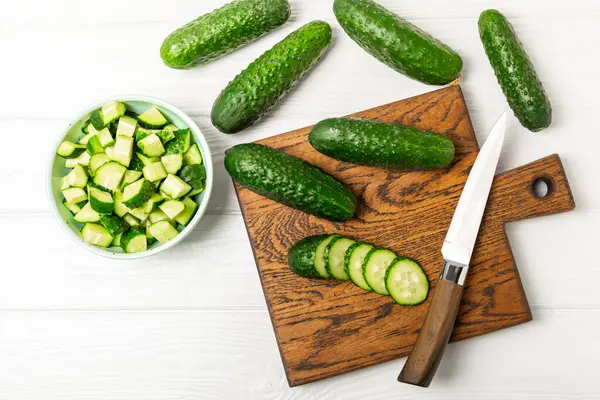 Ahşap arka planda salatalık. Arka planda bir parça salatalık. Taze organik yeşil salatalık turşusu. Vejetaryen. Salata malzemesi. Çiftlik sebzeleri. Sebzeleri bıçakla kes. Mesaj için yer var. Boşluğu kopyala