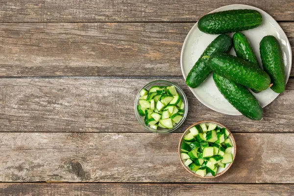 Ahşap arka planda salatalık. Arka planda bir parça salatalık. Taze organik yeşil salatalık turşusu. Vejetaryen. Salata malzemesi. Çiftlik sebzeleri. Sebzeleri bıçakla kes. Mesaj için yer var. Boşluğu kopyala