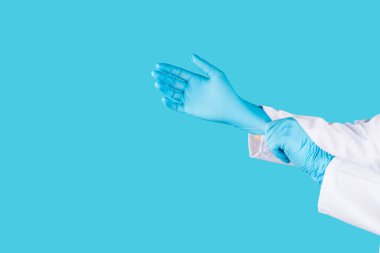 Tıbbi nitril eldivenler, mavi başlık, desenli arka planda tek kullanımlık tıbbi maske. Tıbbi koruyucu giysi. Cerrahi lateks eldivenler. Lastik eldiven üretimi. Tıp konsepti. Üst Manzara. Metni kopyala