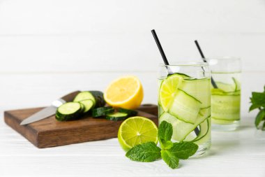 Salatalık suyu, limon, nane ve ahşap bir masada. İçme bardağında dilimlenmiş salatalık ile karıştırılmış su. Tonik ferahlatıcı bir içecek. Salatalık limonata. Doğal soğutma içeceği. Boşluğu kopyala.