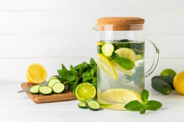 Salatalık suyu, limon, nane ve ahşap bir masada. İçme bardağında dilimlenmiş salatalık ile karıştırılmış su. Tonik ferahlatıcı bir içecek. Salatalık limonata. Doğal soğutma içeceği. Boşluğu kopyala.