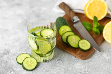 Salatalık suyu, limon, nane ve ahşap bir masada. İçme bardağında dilimlenmiş salatalık ile karıştırılmış su. Tonik ferahlatıcı bir içecek. Salatalık limonata. Doğal soğutma içeceği. Boşluğu kopyala.