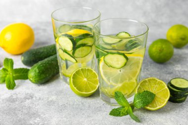 Salatalık suyu, limon, nane ve ahşap bir masada. İçme bardağında dilimlenmiş salatalık ile karıştırılmış su. Tonik ferahlatıcı bir içecek. Salatalık limonata. Doğal soğutma içeceği. Boşluğu kopyala.