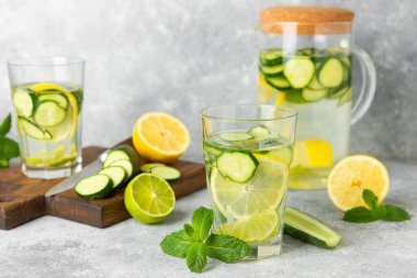 Salatalık suyu, limon, nane ve ahşap bir masada. İçme bardağında dilimlenmiş salatalık ile karıştırılmış su. Tonik ferahlatıcı bir içecek. Salatalık limonata. Doğal soğutma içeceği. Boşluğu kopyala.