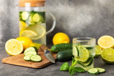 Salatalık suyu, limon, nane ve ahşap bir masada. İçme bardağında dilimlenmiş salatalık ile karıştırılmış su. Tonik ferahlatıcı bir içecek. Salatalık limonata. Doğal soğutma içeceği. Boşluğu kopyala.