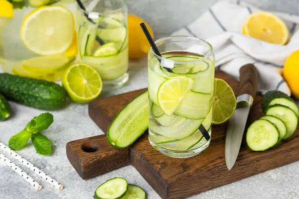 Salatalık suyu, limon, nane ve ahşap bir masada. İçme bardağında dilimlenmiş salatalık ile karıştırılmış su. Tonik ferahlatıcı bir içecek. Salatalık limonata. Doğal soğutma içeceği. Boşluğu kopyala.