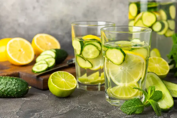 Salatalık suyu, limon, nane ve ahşap bir masada. İçme bardağında dilimlenmiş salatalık ile karıştırılmış su. Tonik ferahlatıcı bir içecek. Salatalık limonata. Doğal soğutma içeceği. Boşluğu kopyala.