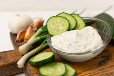 Ahşap bir masada salatalık kremalı tzatziki sosu. Tatar sosu. Geleneksel lezzetli aperatif. Yoğurt sosu. Tzatziki, salatalık, sarımsak, dereotu, limon, nane. Salata sosu. Kopya alanı.