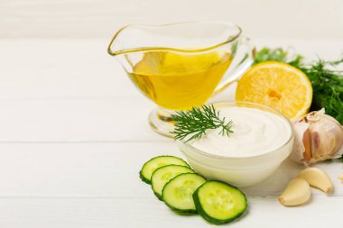 Ahşap bir masada salatalık kremalı tzatziki sosu. Tatar sosu. Geleneksel lezzetli aperatif. Yoğurt sosu. Tzatziki, salatalık, sarımsak, dereotu, limon, nane. Salata sosu. Kopya alanı.