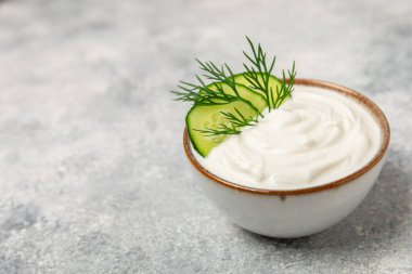 Ahşap bir masada salatalık kremalı tzatziki sosu. Tatar sosu. Geleneksel lezzetli aperatif. Yoğurt sosu. Tzatziki, salatalık, sarımsak, dereotu, limon, nane. Salata sosu. Kopya alanı.