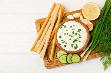 Ahşap bir masada salatalık kremalı tzatziki sosu. Tatar sosu. Geleneksel lezzetli aperatif. Yoğurt sosu. Tzatziki, salatalık, sarımsak, dereotu, limon, nane. Salata sosu. Kopya alanı.