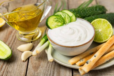 Ahşap bir masada salatalık kremalı tzatziki sosu. Tatar sosu. Geleneksel lezzetli aperatif. Yoğurt sosu. Tzatziki, salatalık, sarımsak, dereotu, limon, nane. Salata sosu. Kopya alanı.