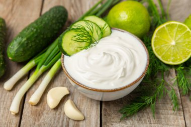Ahşap bir masada salatalık kremalı tzatziki sosu. Tatar sosu. Geleneksel lezzetli aperatif. Yoğurt sosu. Tzatziki, salatalık, sarımsak, dereotu, limon, nane. Salata sosu. Kopya alanı.