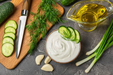 Ahşap bir masada salatalık kremalı tzatziki sosu. Tatar sosu. Geleneksel lezzetli aperatif. Yoğurt sosu. Tzatziki, salatalık, sarımsak, dereotu, limon, nane. Salata sosu. Kopya alanı.