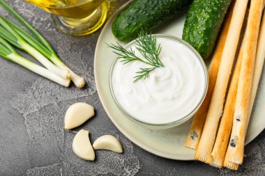 Ahşap bir masada salatalık kremalı tzatziki sosu. Tatar sosu. Geleneksel lezzetli aperatif. Yoğurt sosu. Tzatziki, salatalık, sarımsak, dereotu, limon, nane. Salata sosu. Kopya alanı.