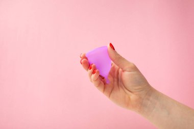 Aybaşı bardağı parlak bir arka planda. Hijyenik peçeteler, tamponlar ve regl kupası. Kritik günler, regl dönemi kavramı. Kadın hijyen ürünü. Kadın sağlığı kavramı. Adet öncesi sendromu. Boşluğu kopyala