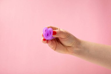 Aybaşı bardağı parlak bir arka planda. Hijyenik peçeteler, tamponlar ve regl kupası. Kritik günler, regl dönemi kavramı. Kadın hijyen ürünü. Kadın sağlığı kavramı. Adet öncesi sendromu. Boşluğu kopyala