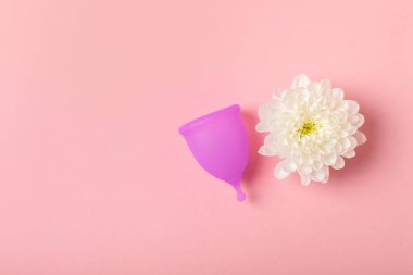 Aybaşı bardağı parlak bir arka planda. Hijyenik peçeteler, tamponlar ve regl kupası. Kritik günler, regl dönemi kavramı. Kadın hijyen ürünü. Kadın sağlığı kavramı. Adet öncesi sendromu. Boşluğu kopyala