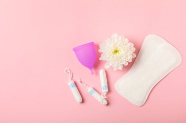 Aybaşı bardağı parlak bir arka planda. Hijyenik peçeteler, tamponlar ve regl kupası. Kritik günler, regl dönemi kavramı. Kadın hijyen ürünü. Kadın sağlığı kavramı. Adet öncesi sendromu. Boşluğu kopyala