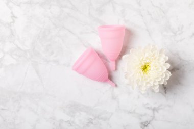 Aybaşı bardağı parlak bir arka planda. Hijyenik peçeteler, tamponlar ve regl kupası. Kritik günler, regl dönemi kavramı. Kadın hijyen ürünü. Kadın sağlığı kavramı. Adet öncesi sendromu. Boşluğu kopyala