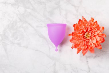 Aybaşı bardağı parlak bir arka planda. Hijyenik peçeteler, tamponlar ve regl kupası. Kritik günler, regl dönemi kavramı. Kadın hijyen ürünü. Kadın sağlığı kavramı. Adet öncesi sendromu. Boşluğu kopyala