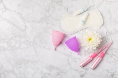 Aybaşı bardağı parlak bir arka planda. Hijyenik peçeteler, tamponlar ve regl kupası. Kritik günler, regl dönemi kavramı. Kadın hijyen ürünü. Kadın sağlığı kavramı. Adet öncesi sendromu. Boşluğu kopyala