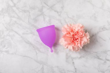 Aybaşı bardağı parlak bir arka planda. Hijyenik peçeteler, tamponlar ve regl kupası. Kritik günler, regl dönemi kavramı. Kadın hijyen ürünü. Kadın sağlığı kavramı. Adet öncesi sendromu. Boşluğu kopyala